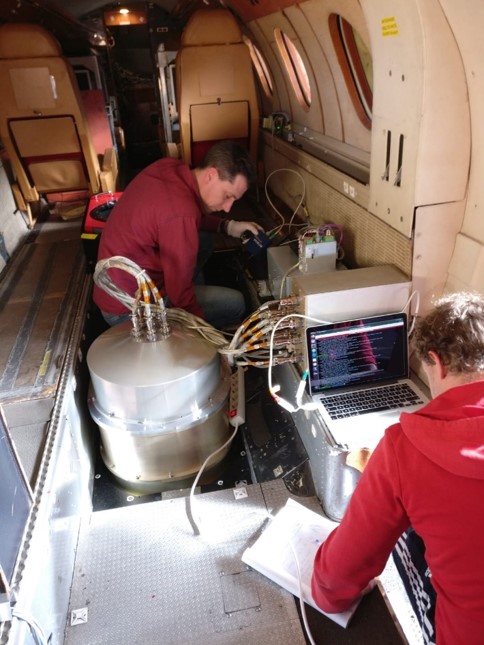 SRON engineers Rob Wolfs (left-back) and Jens Johansen (right-front) inside the Falcon aircraft. SPEX airborne is hidden from sight inside the aluminum dome in the middle